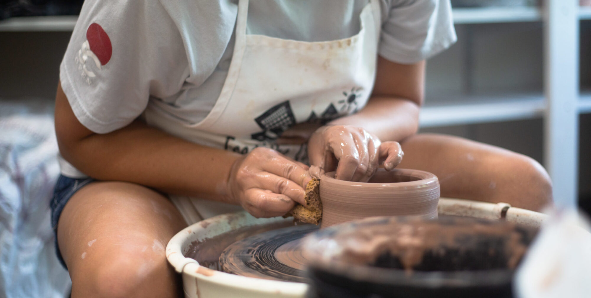 A person working on a pottery wheel.