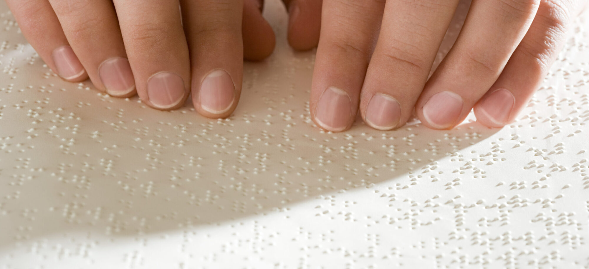 Fingertips of a woman reading Braille