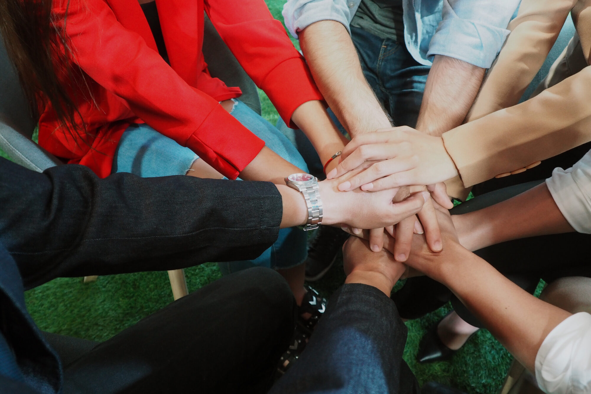 Group Of People stacking Their Hands Together In The Middle In a Meeting