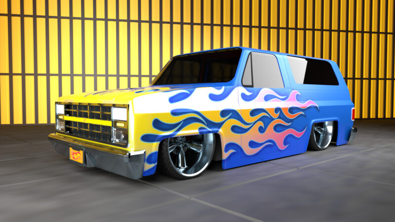 A 1981 Chevrolet K5 Blazer in glossy, medium blue paint with painted, yellow to orange flames from the hood down the side of the vehicle.