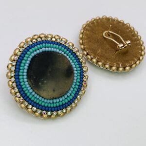 Round earrings in dark stone rimmed by beads of gold, blue, teal, and turquoise.