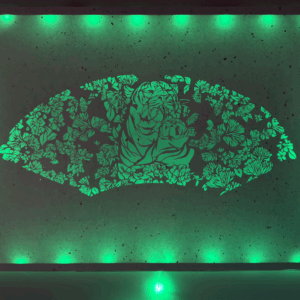 A print of flora and a tiger and tiger cub illuminated by green lighting.