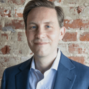 Headshot of Alan Dow, a white man with parted medium dark hair.