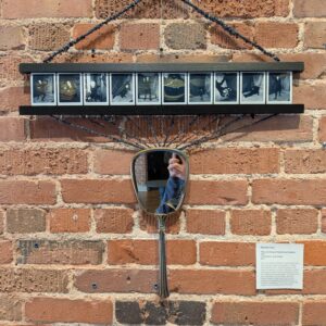An artwork hung on a brick wall