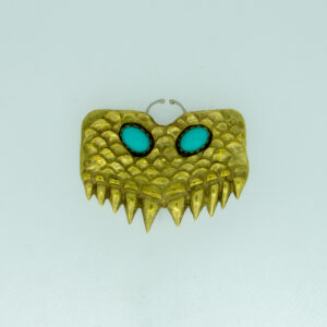 A nose ring crafted to look like a face with brass, azure stones for eyes, and silver