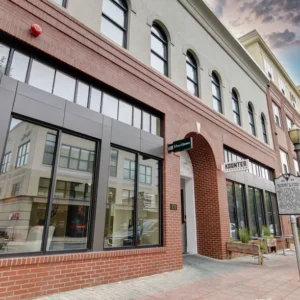 The South Carolina Arts Commission's Olde English Arts Hub office is in a brick storefront with large windows and an arched entry.